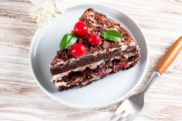 Chocoladebiscuit met kersen op een bord op een houten tafel