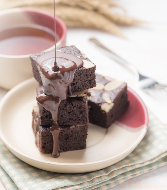 Foto chocoladebrownie met chocoladebovenste laagje op wit hout