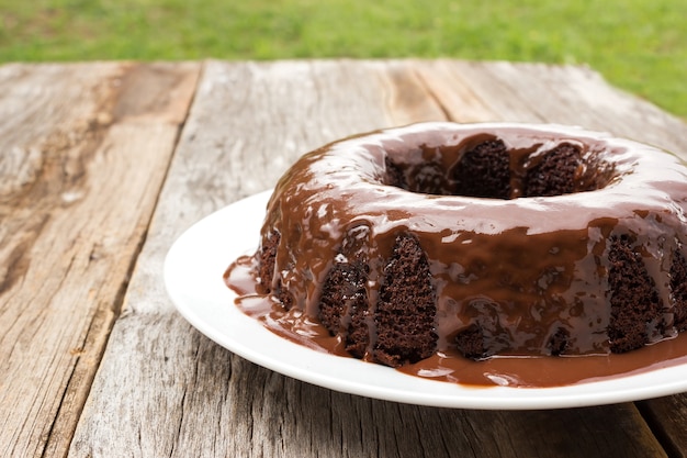 Chocoladecake met chocoladesaus op witte plaat.