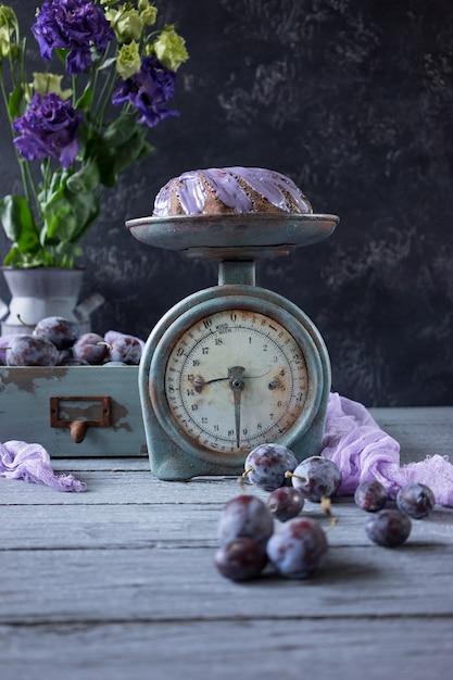 Chocoladecake met lilac bloemen en pruimen in een uitstekende houten doos