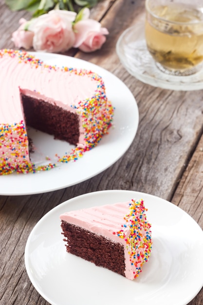 Chocoladecake versieren met roze roomboter en kleurrijke suikerparels.