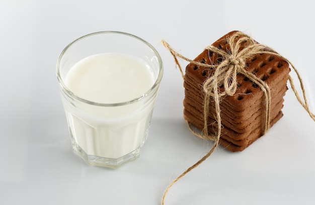 Chocoladekoekjes gebonden met natuurlijk touw en glas melk op witte achtergrond