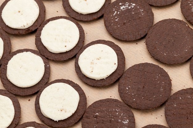 Chocoladekoekjes met romige slagroomvulling, verdeeld in stukjes biscuit en slagroomvulling