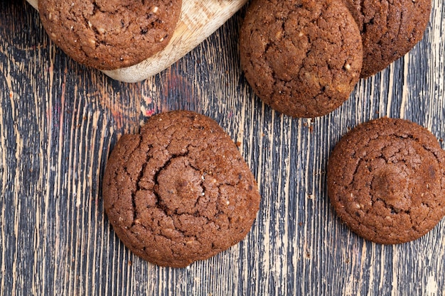 Chocoladekoekjes op een houten tafel, ronde koekjes gemaakt van bloem en een grote hoeveelheid cacao