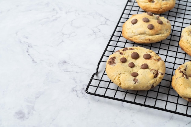 Chocoladekoekjes op metalen rooster over een marmeren tafel met kopieerruimte