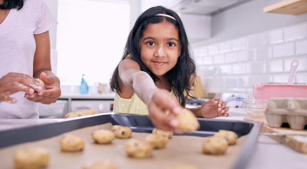 Chocoladekoekjes zijn mijn favoriet Shot van een schattig klein meisje dat koekjesdeeg op een bakplaat legt