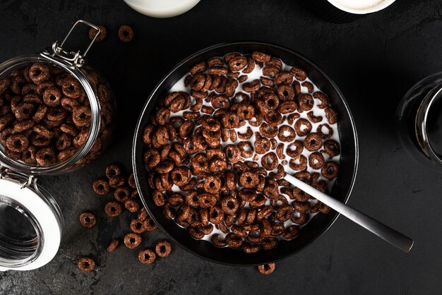 Chocolademaïsringen met melk geïsoleerd op donkere achtergrond Droog ontbijt