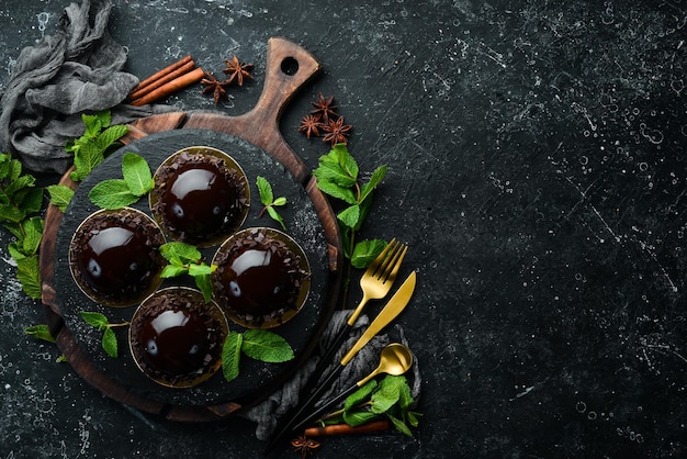 Chocolademousse dessert Opera op een zwart bord met munt Bovenaanzicht Rustieke stijl