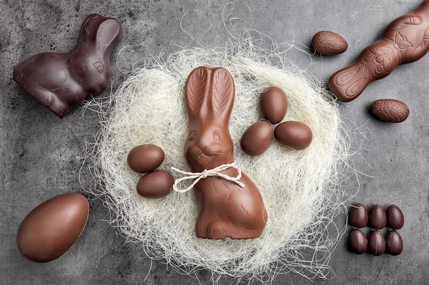 Chocoladepaashaas en eieren in een nest op rustieke achtergrond