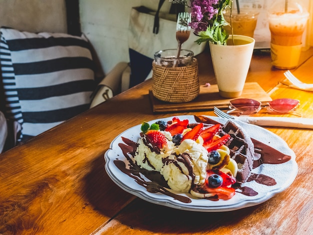 Chocoladepannekoeken met banaan, aardbei, bosbes, roomijs, brownies en chocolade.