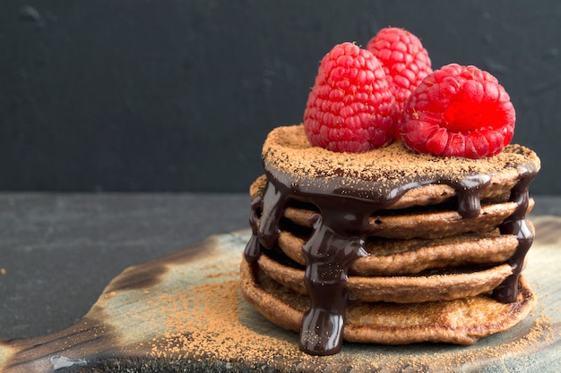 Chocoladepannekoeken met framboos op een donkere achtergrond.