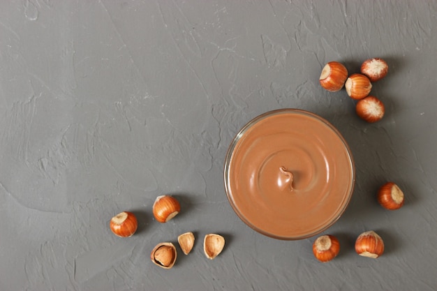 Chocoladepasta in een glazen pot op een gekleurde achtergrond