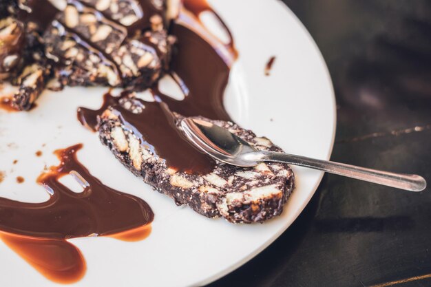 Foto chocoladepasteitjescake met chocoladesaus op een wit bord