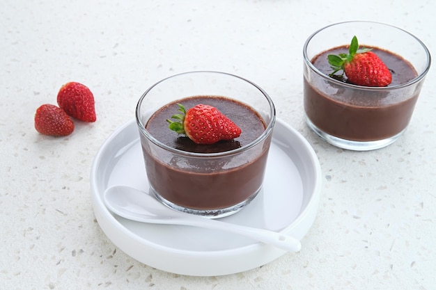 Chocoladepudding met aardbeien in glas op witte tafel Geselecteerde focus