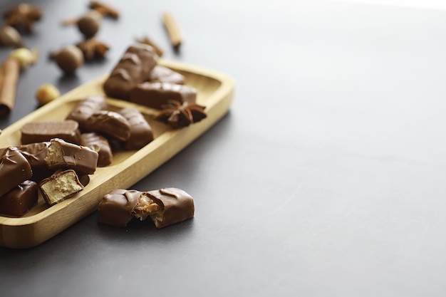 Chocoladerepen op een zwarte achtergrond in tegenlicht. chocolade met vulling. zoete snoepjes voor snack en thee.