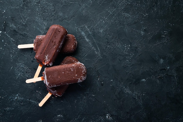 Chocoladeroomijs op een stokje Op een zwarte achtergrond Bovenaanzicht Gratis kopieerruimte