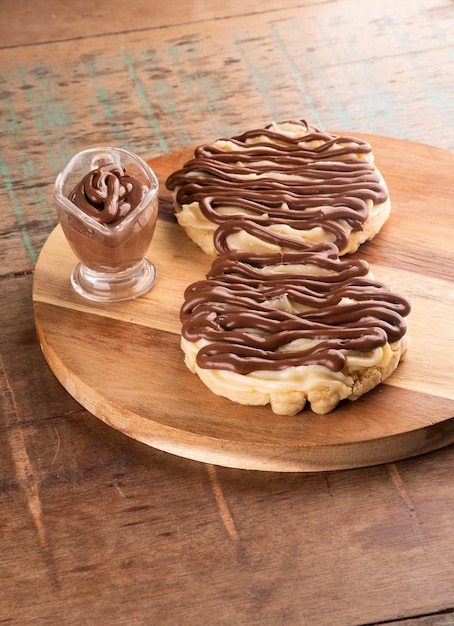 Chocoladeroomwafel met hazelnoot en witte chocolade op houten bord op rustiek tafelportret