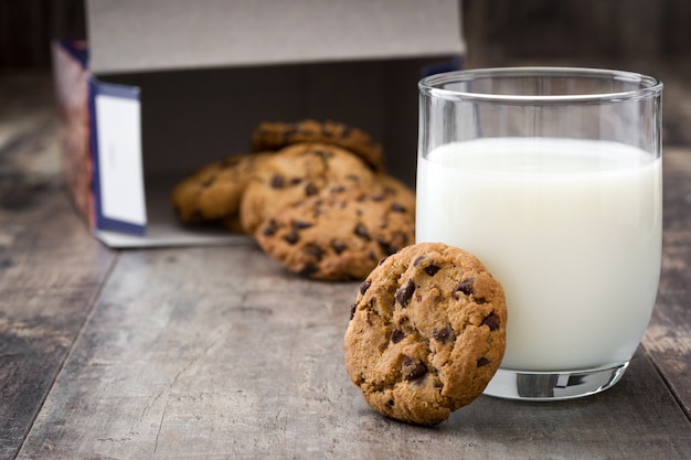 Chocoladeschilferkoekjes en melk op de houten ruimte van het lijstexemplaar