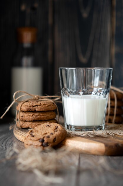 Chocoladeschilferkoekjes en melk op houten lijst