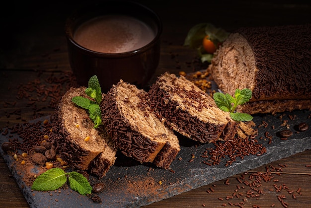 Chocoladeschilferkoekjes in de vorm van een blok, porties, muntblaadjes op met een kopje cacao op een bruin