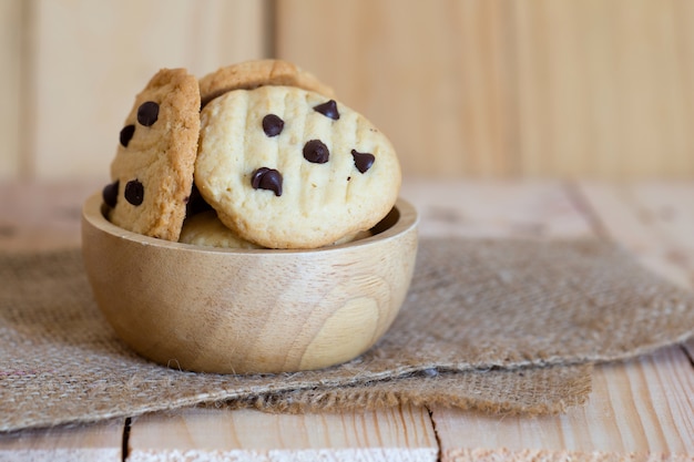 Chocoladeschilferkoekjes in kop houten op houten lijst