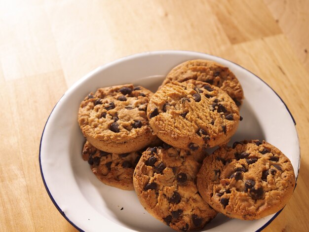 Chocoladeschilferkoekjes op een houten tafel Chocoladekoekjes op een tinnen bord op een houten tafel