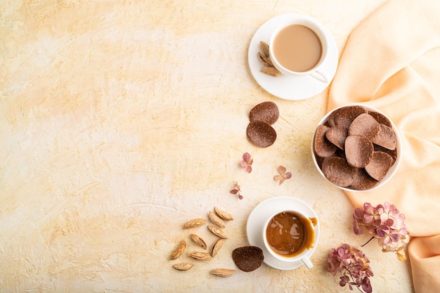 Chocoladeschilfers met kopje koffie op een beige betonnen achtergrond bovenaanzicht kopie ruimte