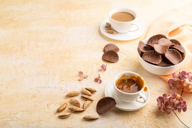 Chocoladeschilfers met kopje koffie op een beige betonnen achtergrond zijaanzicht kopie ruimte