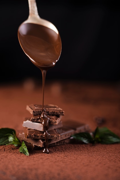 Foto chocoladesiroop over chocoladereepvierkanten gegoten