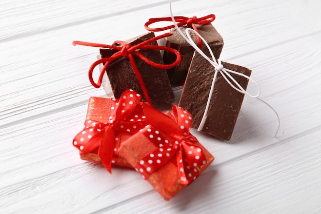 Chocoladestukjes met cadeautjes op houten ondergrond