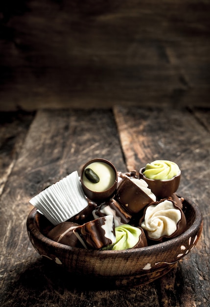 Chocoladesuikergoed in een kom. Op een houten achtergrond.