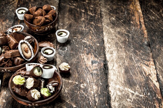 Chocoladesuikergoed in kommen. Op een houten tafel.