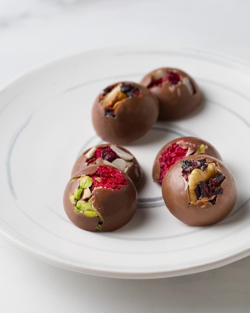 Chocoladesuikergoed met noten Heerlijk dessert op een lichte achtergrond Snoepjes op een witte plaat