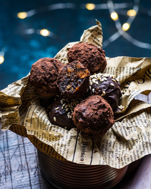 Chocoladesuikergoedtruffel met chocoladestukken en vliegend cacaopoeder op een donkere achtergrond. Gezond snoep. Veganistisch snoep. Nieuwjaars dessert. Kerst dessert. Valentijnsdag