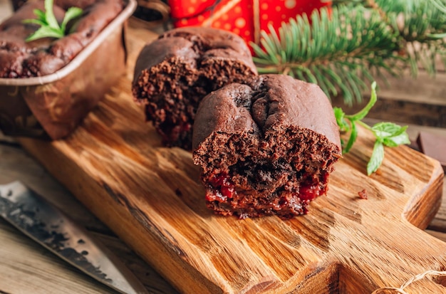 Chocoladetaart brownies voor een geschenk op een houten snijplank met kerstversieringen op een rustiek