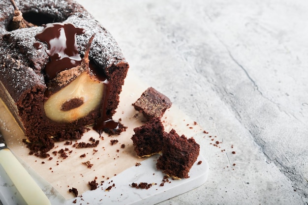 Chocoladetaart met peren binnen gebakken Chocolade perentaart of donkere chocolade bundt cake met peer op lichtgrijze tafel thuis Thuis koken en bakken recepten concept Selectieve focus