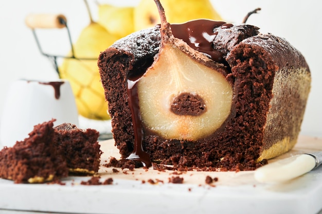 Chocoladetaart met peren binnen gebakken Chocolade perentaart of donkere chocolade bundt cake met peer op lichtgrijze tafel thuis Thuis koken en bakken recepten concept Selectieve focus