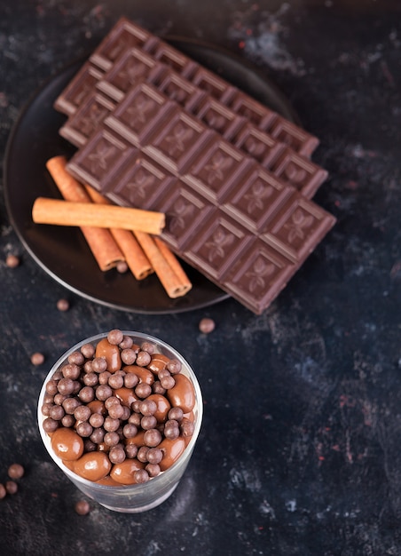 Chocoladetablet naast andere snoepjes op donkere houten ondergrond