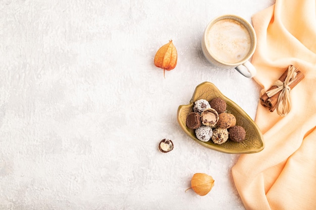 Chocoladetruffelsnoepjes met kopje koffie op een grijze betonnen achtergrond bovenaanzicht kopie ruimte