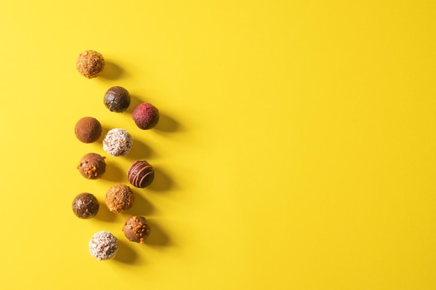 Chocoladetruffelsnoepjes met verschillende vullingen op een felgele achtergrond