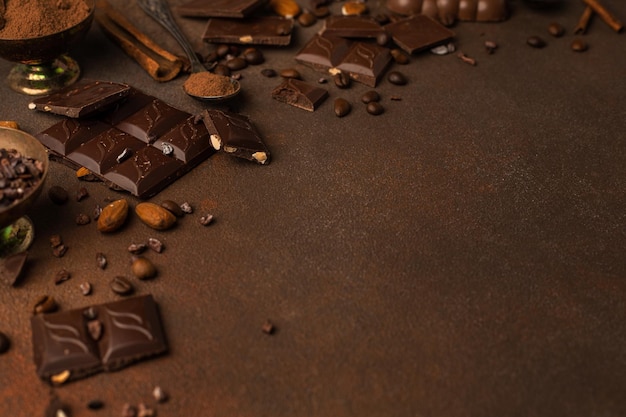 Шоколадный фон с кусочками шоколада, шоколадной стружкой, орехами, какао