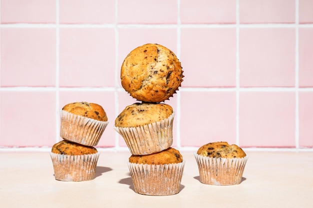 Foto muffin al cioccolato e banana in pila sparata su sfondo colorato luce dura orizzontale