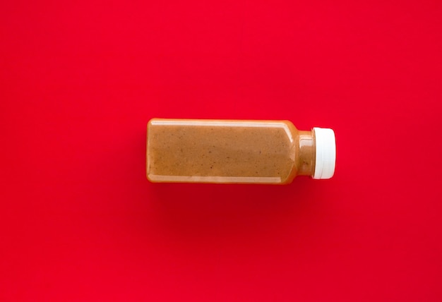 Chocolate banana smoothie bottle on red flatlay