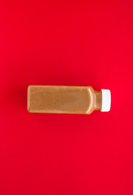 Chocolate banana smoothie bottle on red flatlay