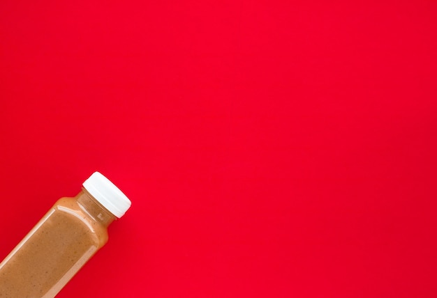 Chocolate banana smoothie bottle on red flatlay