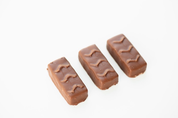 白い背景で隔離のキャラメルとピーナッツとチョコレートバー