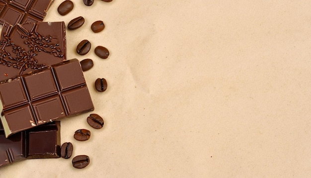 A chocolate bar with coffee beans on a brown paper