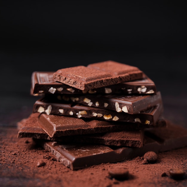 Foto torre di barrette di cioccolato con cacao in polvere