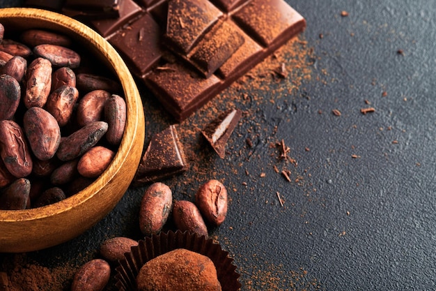 Chocolate bean cocoa Composition of cocoa powder bean cocoa bars and pieces of different milk and dark chocolate on black background Baking Chocolate Texture Top view with copy space Mock up