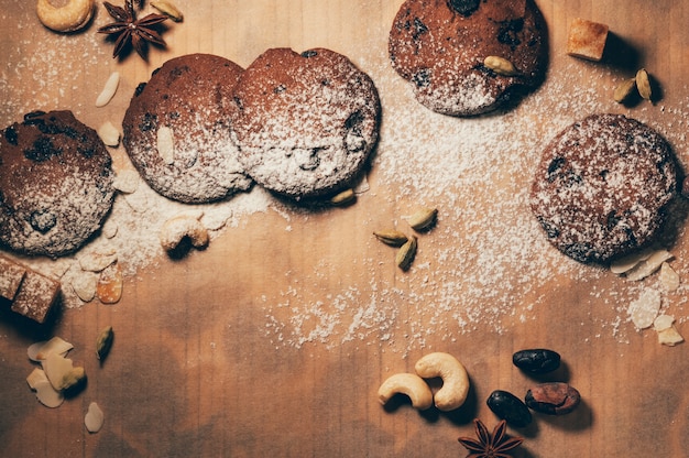 Chocolate biscuits with spices, nuts and flour on table